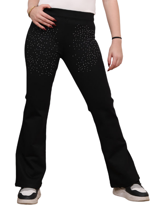 Woman wearing black pants with white polka dots on a white background